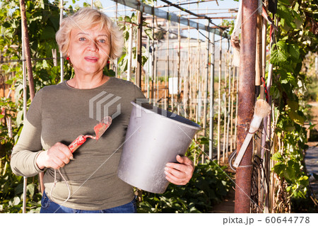 Woman with various garden accessories 60644778