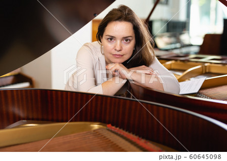 Young woman in an evening dress at the piano Young woman in an evening dress at the piano 60645098