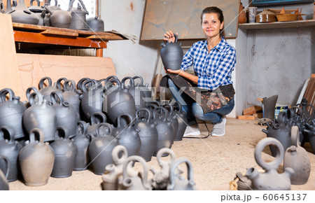 Woman chooses pots clay pots in store warehouse Woman chooses pots clay pots in store warehouse 60645137