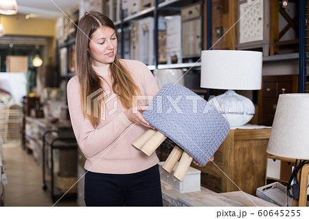 smiling woman buyer choosing pouf 60645255