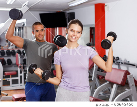 Man and woman posing with dumbbells 60645450