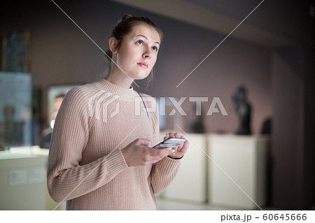 Female visitor touching phone in the historical museum 60645666