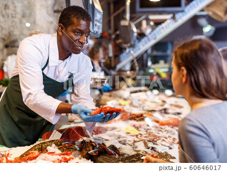 Salesman serving customer shrimps 60646017