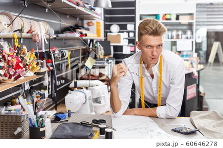 Tailor using tape measure for creating pattern 60646278
