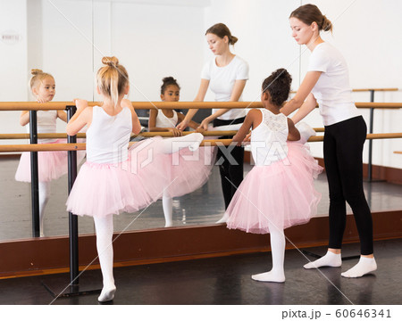 Girls practicing elements on ballet barre 60646341