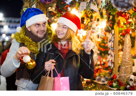 Girl with boy in Christmas hat choosing decorations 60646379