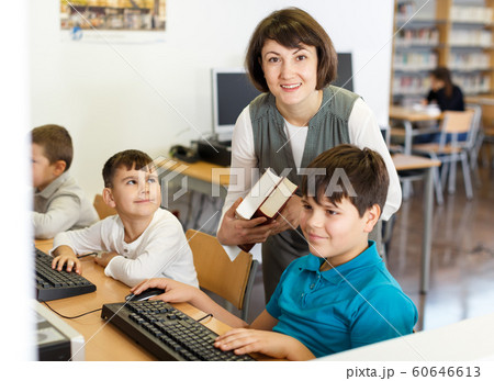 Female teacher working with pupil in computer class Female teacher working with pupil in computer class 60646613