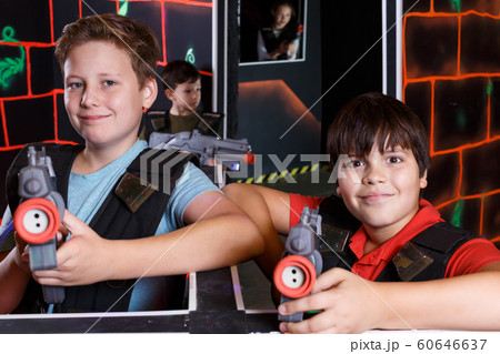 Two glad teen boys standing with laser guns 60646637