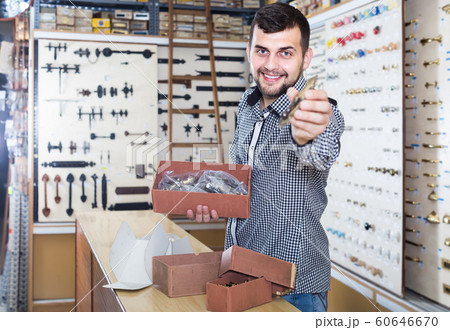 male seller sorting boxes with door handles in houseware shop 60646670