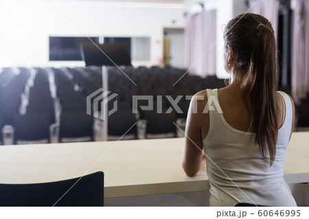 Woman sitting opposite to empty hall Woman sitting opposite to empty hall 60646995