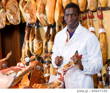 Salesman checking quality of ham 60647140