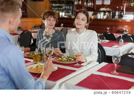Women with male colleague at restaurant dinner Women with male colleague at restaurant dinner 60647259