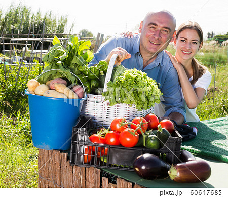 Happy family of gardeners posing with harvest of vegetables and greens Happy family of gardeners posing with harvest of vegetables and greens 60647685