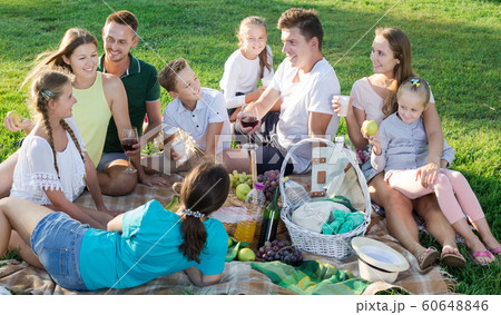 Group of joyful people with kids enjoying picnic Group of joyful people with kids enjoying picnic 60648846