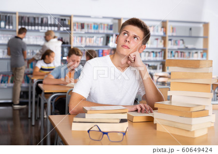 Bored schoolboy in college library 60649424