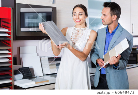 Couple choosing material for facades for their future kitchen Couple choosing material for facades for their future kitchen 60649473