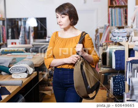 Pensive female customer in cloth store Pensive female customer in cloth store 60649665