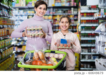 Female shopper with teenage daughter searching for eggs Female shopper with teenage daughter searching for eggs 60649679