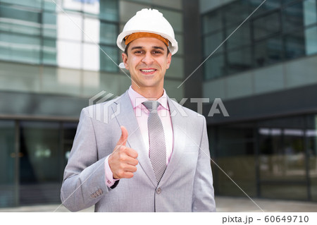 Businessman in hardhat showing thumbs up Businessman in hardhat showing thumbs up 60649710