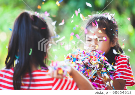 asian child girl and her sister play with colorful confetti together 60654612