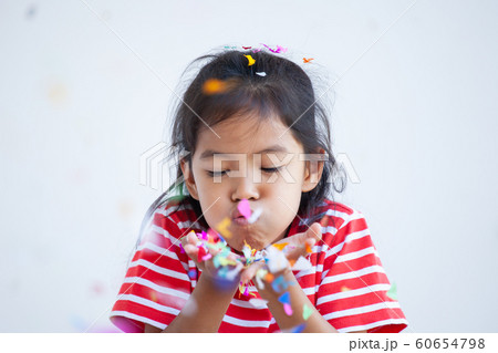 asian child girl with colorful confetti to celebrate in her party 60654798