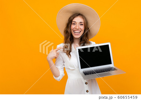 Beautiful caucasian woman in costume works with laptop isolated on yellow background Beautiful caucasian woman in costume works with laptop isolated on yellow background 60655459