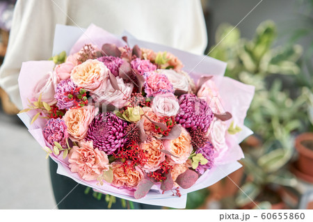 European floral shop. Beautiful bouquet of mixed flowers in womans hands. the work of the florist at a flower shop. Delivery fresh cut flower. European floral shop. Beautiful bouquet of mixed flowers in womans hands. the work of the florist at a flower shop. Delivery fresh cut flower. 60655860