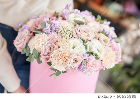 European floral shop. Floral bunch in round box. Bouquet of beautiful Mixed flowers in woman hand. Excellent garden flowers in the arrangement , the work of a professional florist. European floral shop. Floral bunch in round box. Bouquet of beautiful Mixed flowers in woman hand. Excellent garden flowers in the arrangement , the work of a professional florist. 60655989