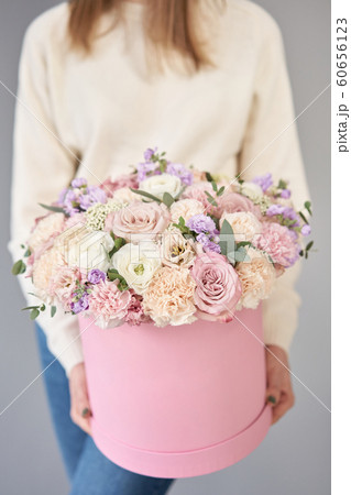 European floral shop. Floral bunch in round box. Bouquet of beautiful Mixed flowers in woman hand. Excellent garden flowers in the arrangement , the work of a professional florist. 60656123