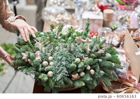 A woman decorates a Christmas arrangement. Master class on making decorative ornaments. Christmas decor with their own hands. The new year celebration. Flower shop 60656163