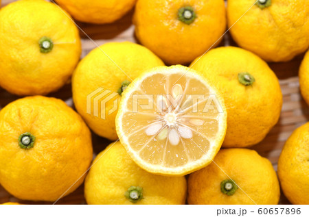 沢山のユズ・たくさんのユズをバックにカットされた柚子 60657896