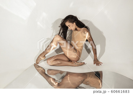Young and stylish modern ballet dancer on white background with mirrors 60661683