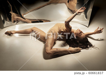 Young and stylish modern ballet dancer on white background with mirrors 60661837