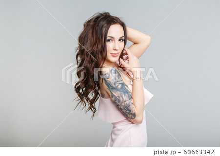 Beautiful young woman with stylish tattoo on hand Beautiful young woman with stylish tattoo on hand 60663342