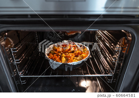 Baked potatoes with carrot and other spices in roasting pan. Baked potatoes with carrot and other spices in roasting pan. 60664581