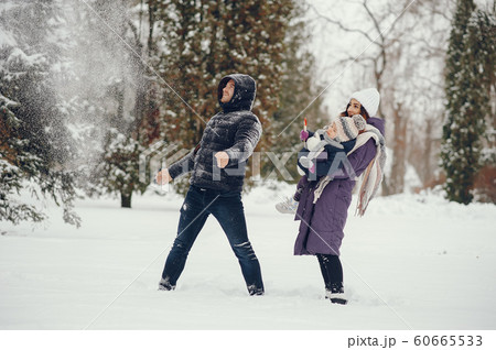 Little girl with parents in a winter park 60665533