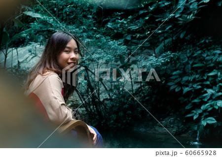 Happy young woman have a rest in garden near a pond. Happy young woman have a rest in garden near a pond. 60665928