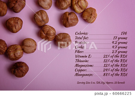 Peeled hazelnut on a pink background. 60666225