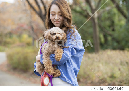 ペットを抱っこする若い女性の写真素材