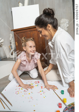 Nice little girl making nice picture with painted coloured palms Nice little girl making nice picture with painted coloured palms 60669707