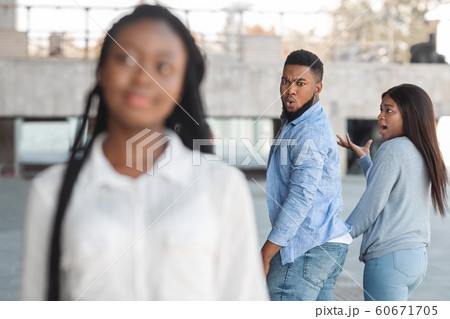 Guy turning and looking to another woman while walking with girlfriend Guy turning and looking to another woman while walking with girlfriend 60671705