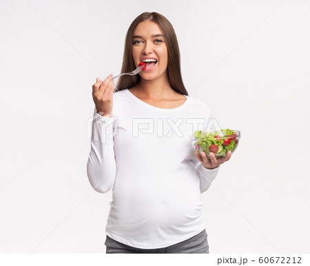 Happy Pregnant Woman Eating Vegetable Salad, Studio Shot 60672212