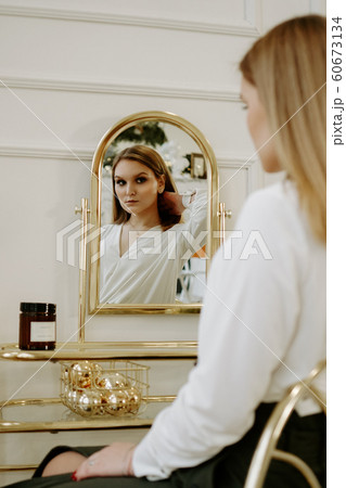 Beautiful woman in her room near her dressing table Beautiful woman in her room near her dressing table 60673134