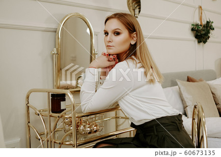 Beautiful woman in her room near her dressing table Beautiful woman in her room near her dressing table 60673135