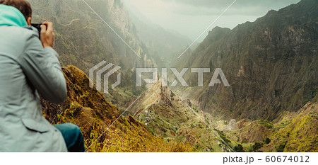 Rear view of traveler making photo of amazing steep mountainous terrain with lush canyon valley on the path from Xo-Xo Valley. Santo Antao Island, Cape Verde 60674012
