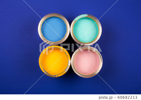 Four open cans of paint with brushes on bright background. 60682213