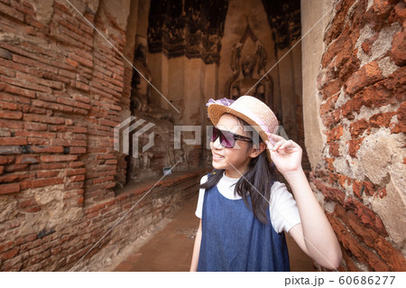 Cute happy smiling tourist girl,relaxing enjoying travelling at Wat Chaiwatthanaram is a Buddhist temple in the city of Ayutthaya Historical Park,Thailand, summer vacation,travel concept. Cute happy smiling tourist girl,relaxing enjoying travelling at Wat Chaiwatthanaram is a Buddhist temple in the city of Ayutthaya Historical Park,Thailand, summer vacation,travel concept. 60686277