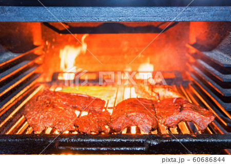 Grilling pork ribs in stove close up Grilling pork ribs in stove close up 60686844