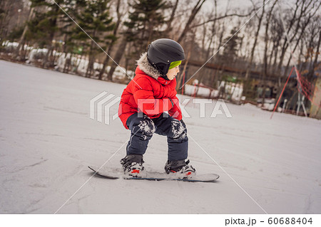 Little cute boy snowboarding. Activities for children in winter. Children's winter sport. Lifestyle 60688404