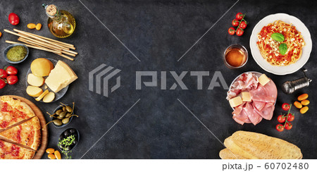 Italian food panorama with a place for text. Pizza, pasta, cheese, hams, olives and olive oil, and wine, overhead shot on a black background, a frame, a flat lay design template for a restaurant menu Italian food panorama with a place for text. Pizza, pasta, cheese, hams, olives and olive oil, and wine, overhead shot on a black background, a frame, a flat lay design template for a restaurant menu 60702480